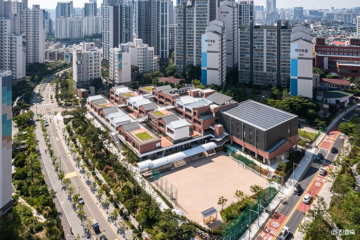 [고층아파트 옆에 낮게 펼쳐진 신길중학교 전경]